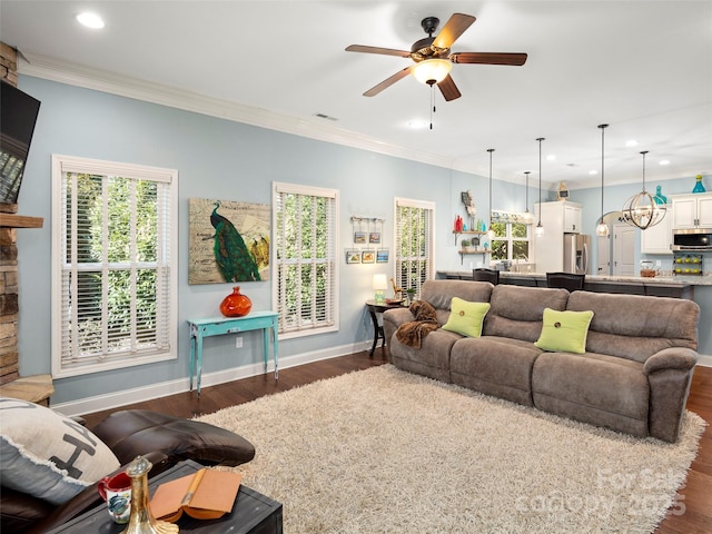 living area with dark wood-type flooring, visible vents, crown molding, and baseboards