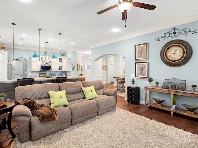 living room featuring recessed lighting, arched walkways, dark wood finished floors, and ornamental molding