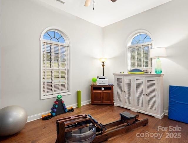 workout room featuring ceiling fan, baseboards, and wood finished floors