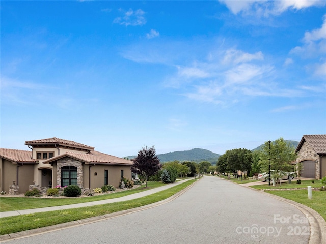 view of road featuring curbs, sidewalks, and a mountain view