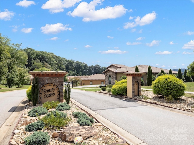 view of road with curbs and a gated entry