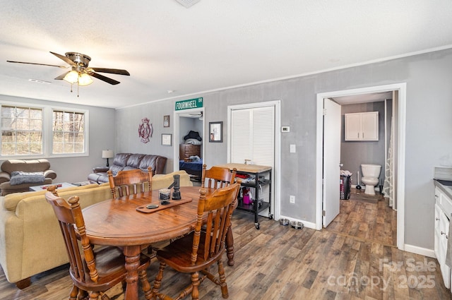 dining space with crown molding, wood finished floors, a ceiling fan, and baseboards