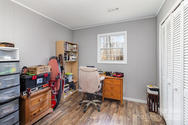 office area featuring baseboards, wood finished floors, visible vents, and crown molding