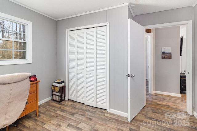 home office featuring crown molding, baseboards, and wood finished floors