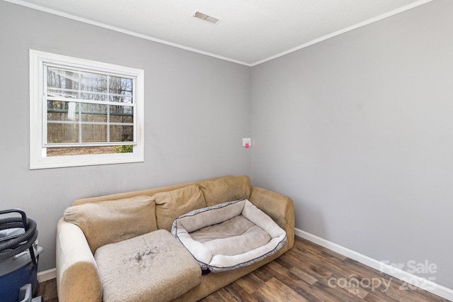 interior space with baseboards, crown molding, visible vents, and wood finished floors