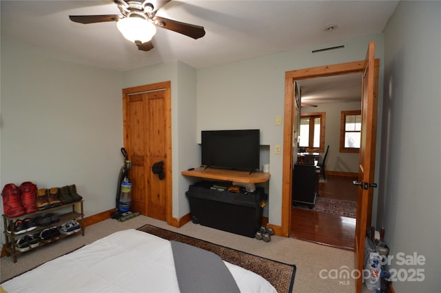 carpeted bedroom with ceiling fan, visible vents, and baseboards