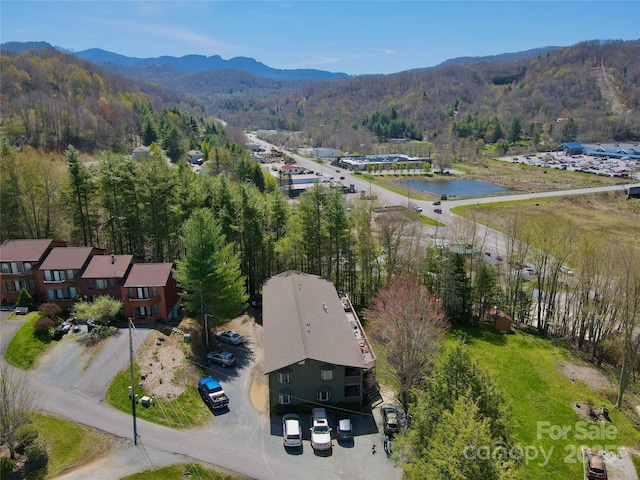 aerial view with a forest view and a water and mountain view