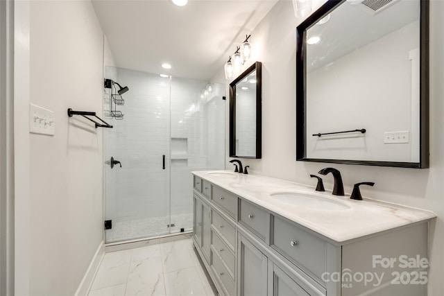 full bath featuring a stall shower, marble finish floor, visible vents, and a sink