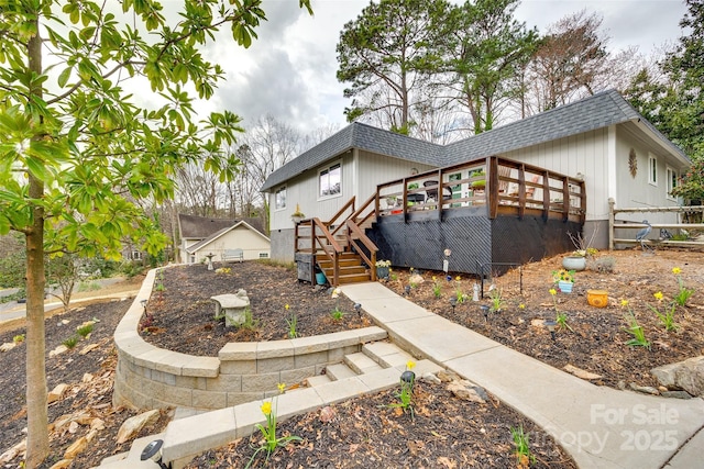 view of front of property with stairs, a shingled roof, and a deck