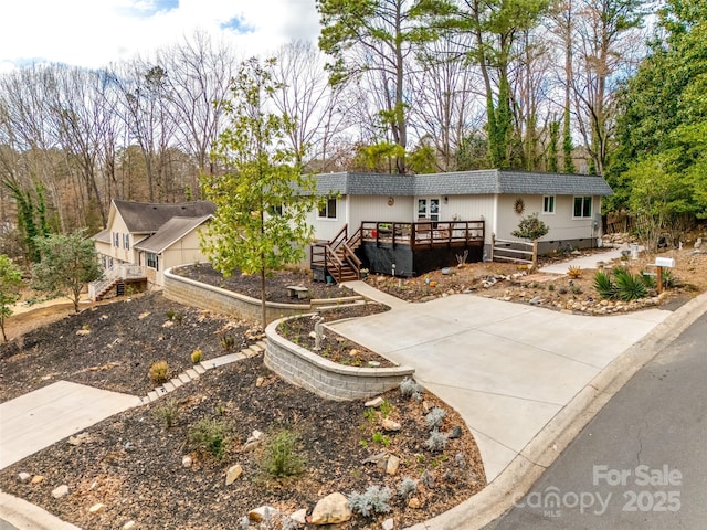 ranch-style house with stairway, concrete driveway, and a wooden deck