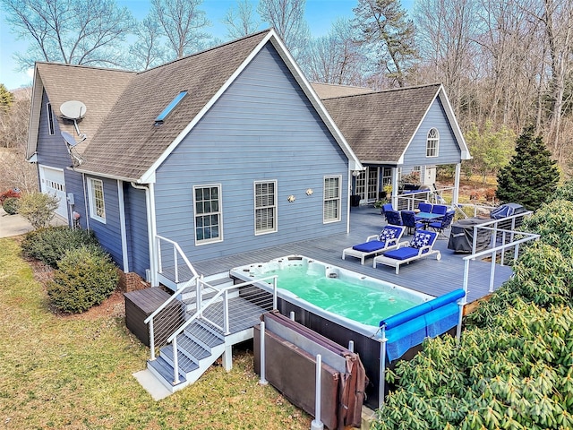 back of house featuring roof with shingles, an outdoor hot tub, and a wooden deck