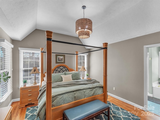 bedroom featuring lofted ceiling, a textured ceiling, light wood-style flooring, and baseboards