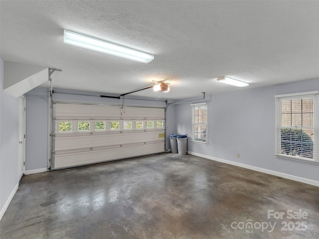 garage with baseboards and a garage door opener