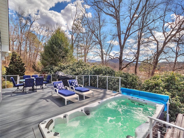 view of swimming pool featuring outdoor dining area, hot tub deck surround, and a deck