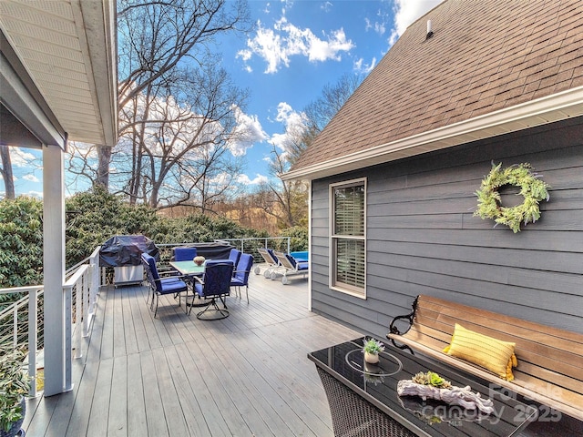 wooden deck featuring a grill and outdoor dining area