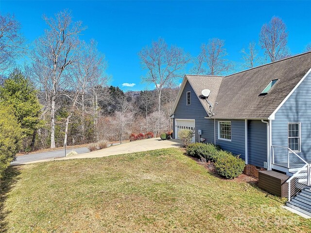 view of yard with a garage and driveway