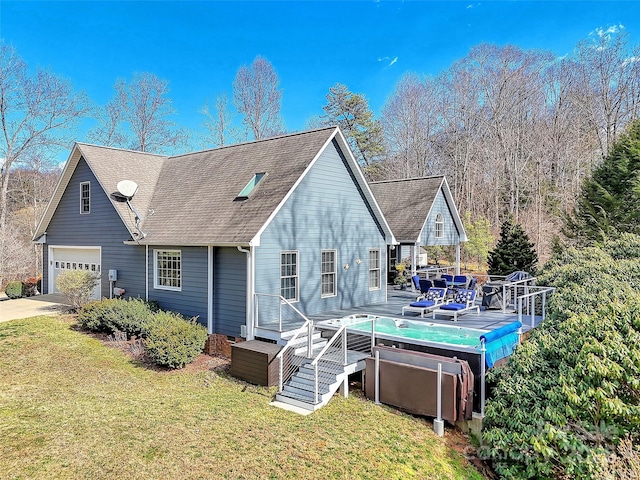 back of house featuring driveway, a shingled roof, a deck, a yard, and a pool