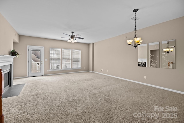 unfurnished living room with ceiling fan with notable chandelier, carpet floors, a fireplace with flush hearth, and baseboards