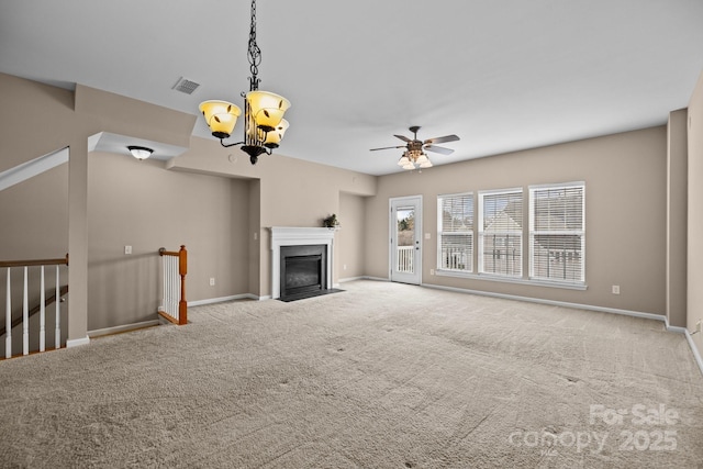 unfurnished living room featuring carpet floors, a fireplace with flush hearth, visible vents, and baseboards