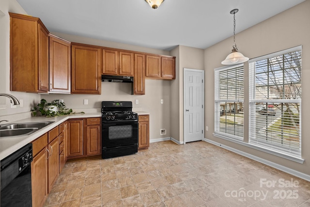 kitchen featuring light countertops, brown cabinetry, a sink, under cabinet range hood, and black appliances