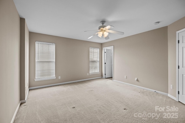 unfurnished room with a ceiling fan, baseboards, and carpet flooring