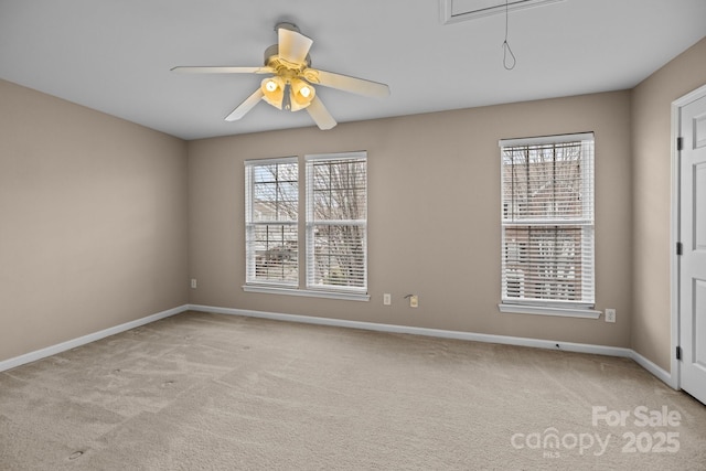 spare room featuring plenty of natural light, carpet flooring, attic access, and baseboards