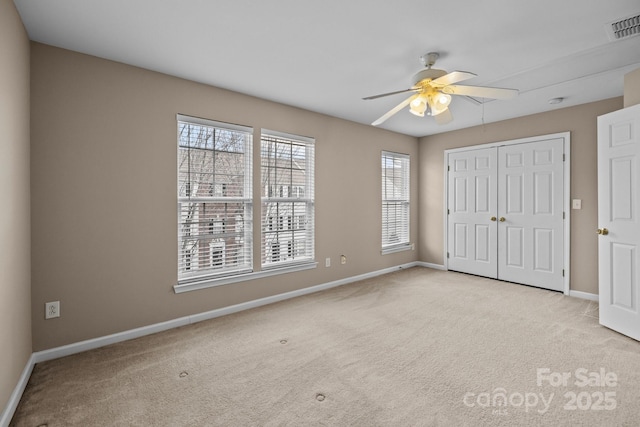 unfurnished bedroom with baseboards, a closet, visible vents, and carpet flooring