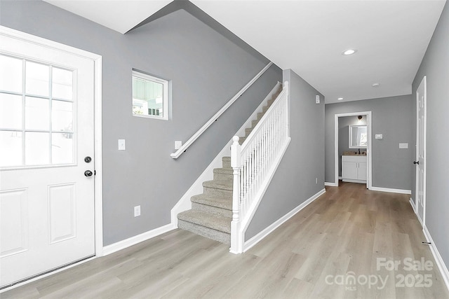 entrance foyer with recessed lighting, baseboards, light wood finished floors, and stairs