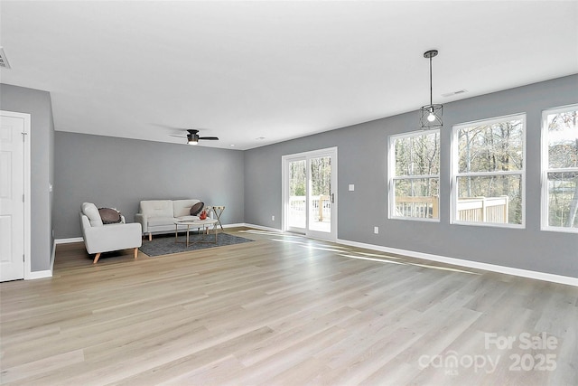 sitting room with a ceiling fan, visible vents, light wood-style flooring, and baseboards