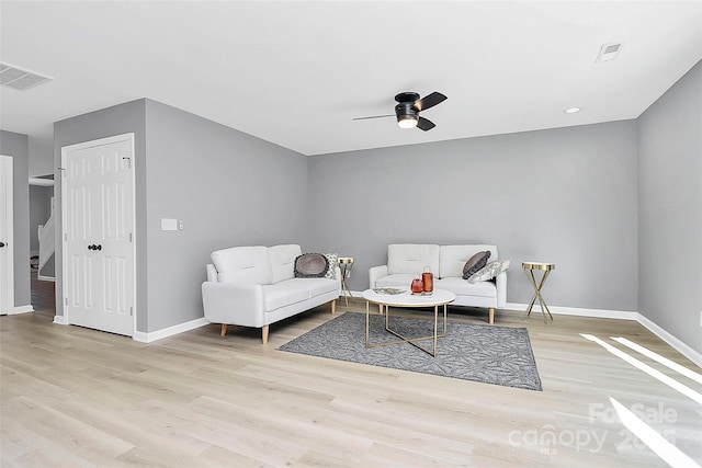 sitting room featuring a ceiling fan, visible vents, baseboards, and wood finished floors