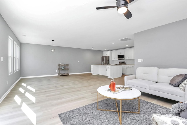 living room with recessed lighting, a ceiling fan, baseboards, visible vents, and light wood-style floors