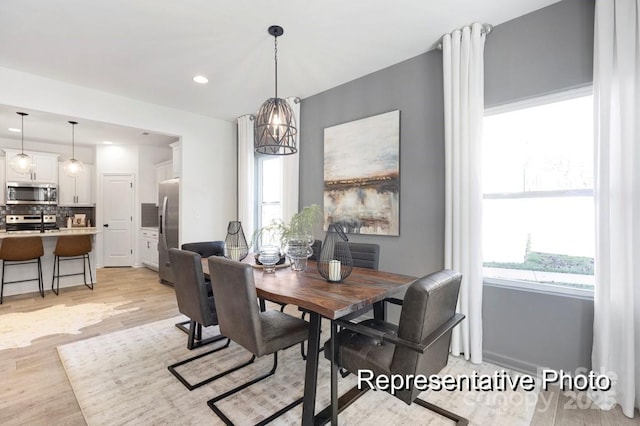 dining area featuring light wood-style flooring, a wealth of natural light, and recessed lighting