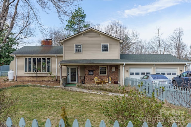 tri-level home featuring an attached garage, covered porch, brick siding, fence, and a front yard