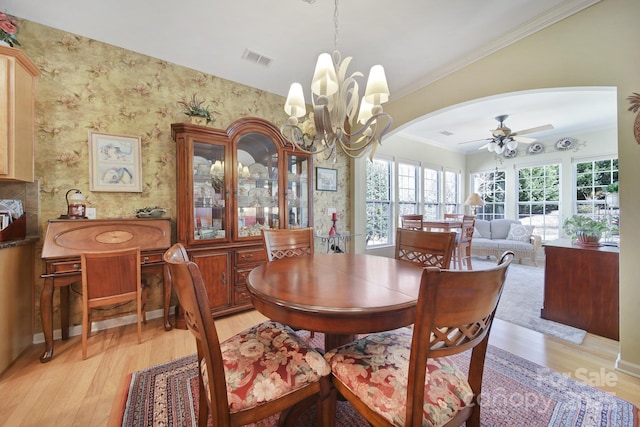 dining room featuring light wood-type flooring, visible vents, wallpapered walls, and ceiling fan with notable chandelier