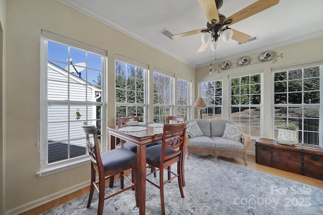 sunroom / solarium with ceiling fan, plenty of natural light, and visible vents