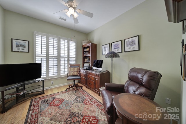 office area with light wood-style floors, visible vents, ceiling fan, and baseboards