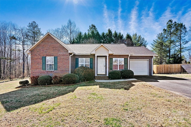 single story home with driveway, an attached garage, fence, a front lawn, and brick siding