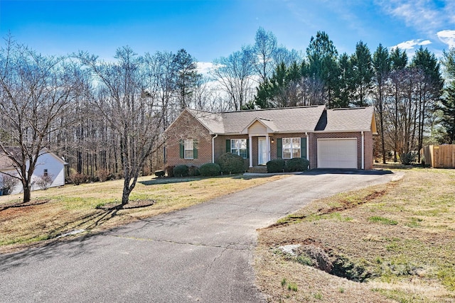 single story home featuring a garage, brick siding, fence, driveway, and a front yard