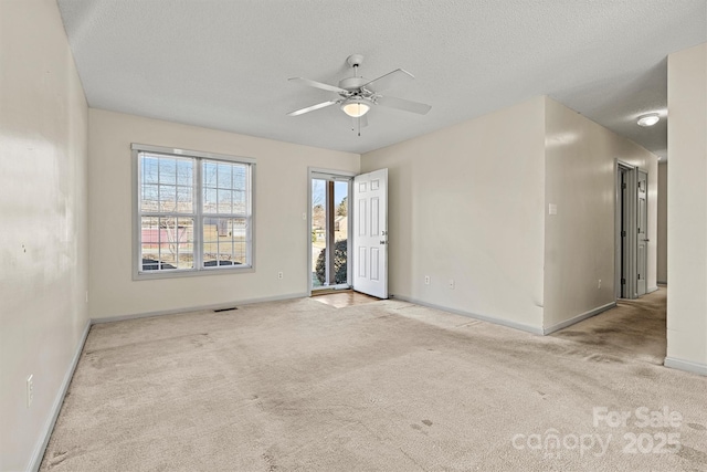 spare room featuring carpet floors, a textured ceiling, and baseboards