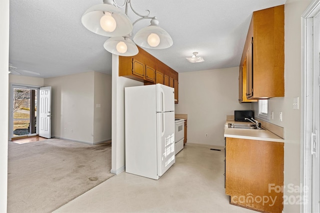 kitchen with light countertops, white appliances, plenty of natural light, and brown cabinets