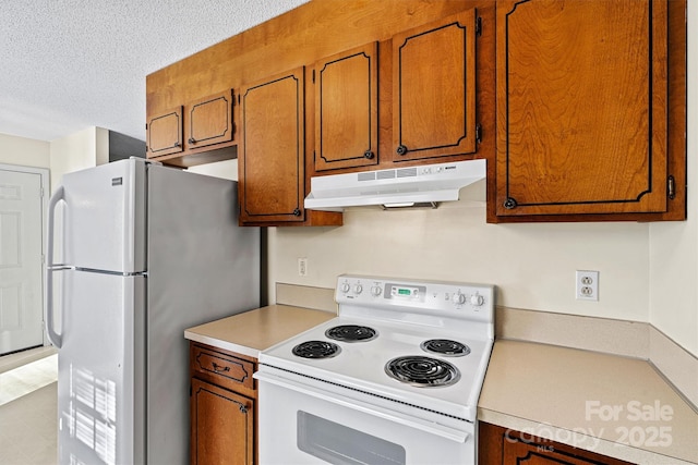 kitchen with light countertops, white appliances, brown cabinetry, and under cabinet range hood