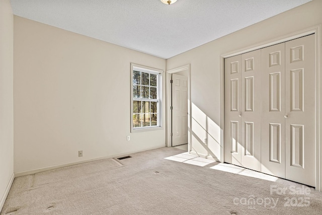 interior space featuring baseboards, visible vents, and a textured ceiling