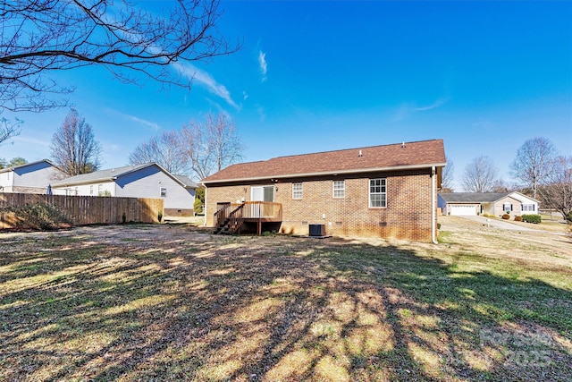 back of property with central AC, brick siding, fence, crawl space, and a lawn