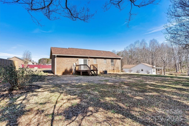 rear view of house featuring brick siding and central AC unit