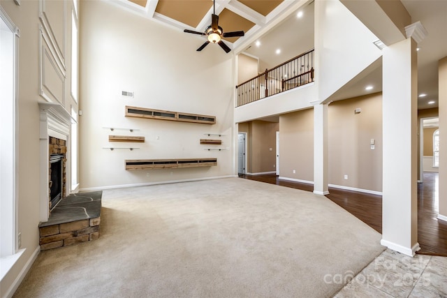 unfurnished living room featuring decorative columns, visible vents, coffered ceiling, ceiling fan, and a fireplace