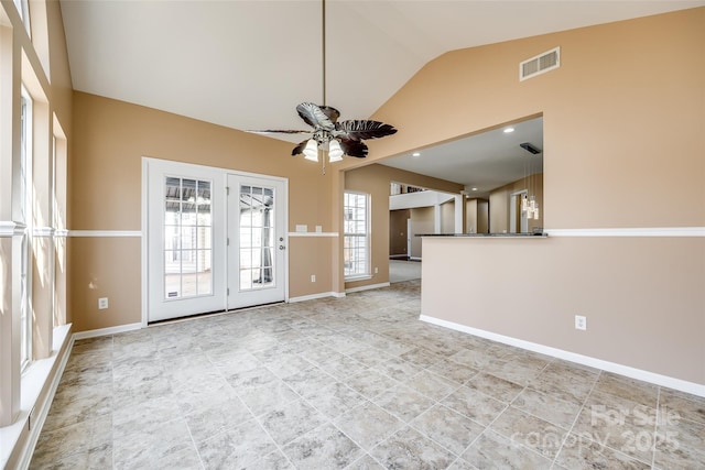 spare room featuring visible vents, vaulted ceiling, baseboards, and ceiling fan