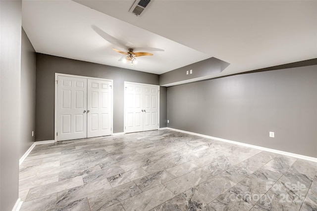 unfurnished bedroom with ceiling fan, two closets, visible vents, and baseboards