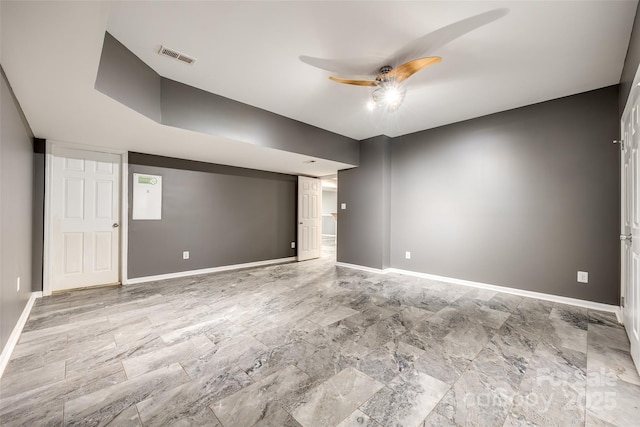 empty room featuring a ceiling fan, visible vents, and baseboards