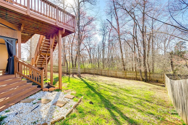 view of yard featuring a fenced backyard, stairway, and a deck