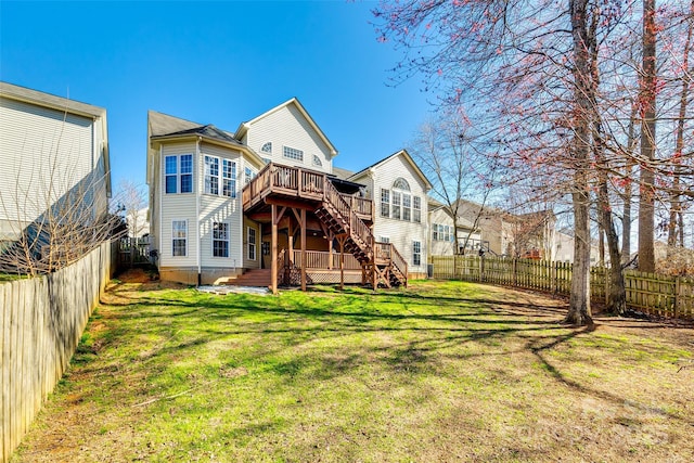 rear view of house featuring a fenced backyard, a yard, a wooden deck, and stairs